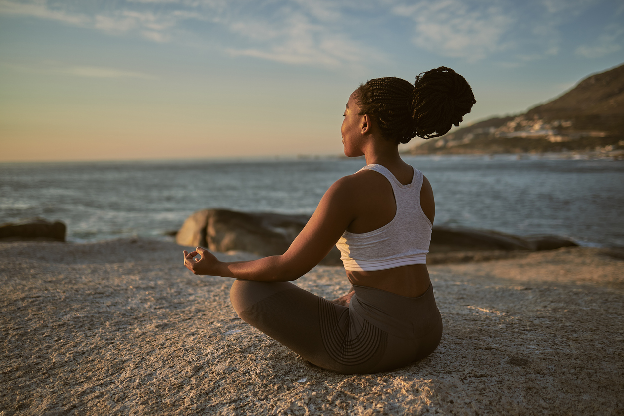 person meditating on beach